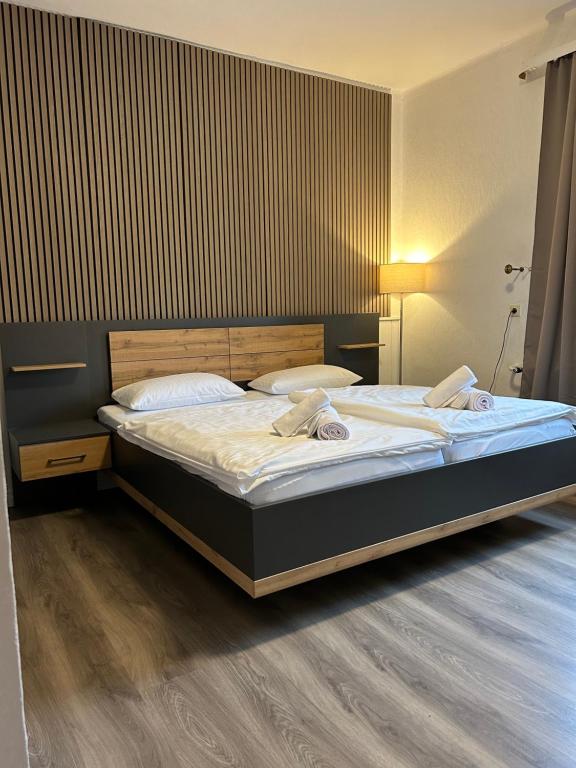 Bett mit Holzlamellenwand